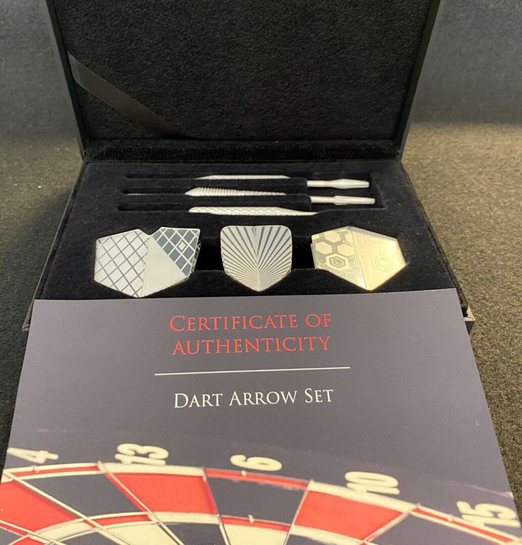 A box with darts in it and three different types of darts.