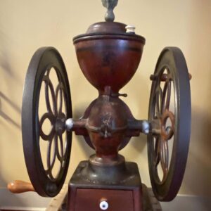 A coffee grinder with wheels on the top of it.