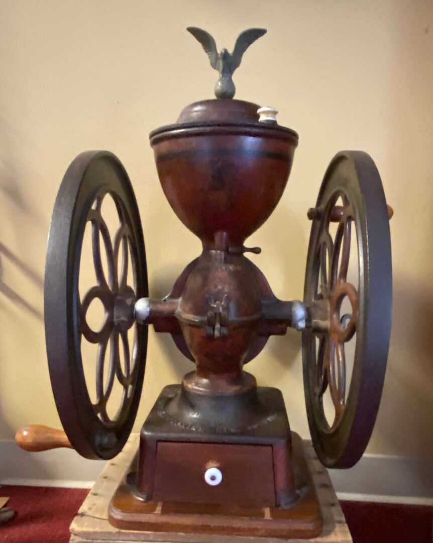A coffee grinder with wheels on the top of it.