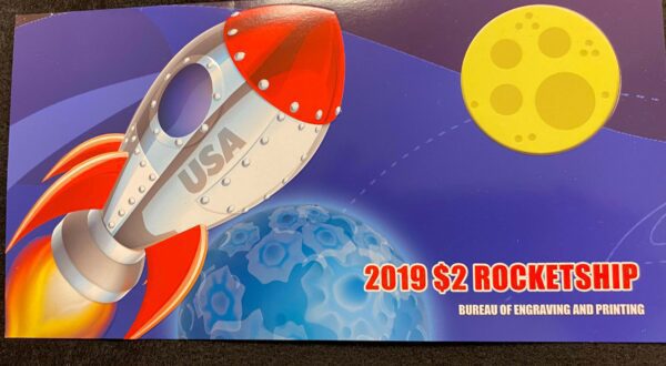 A 2 0 1 9 $ 2 rocket ship coin is shown in this image.