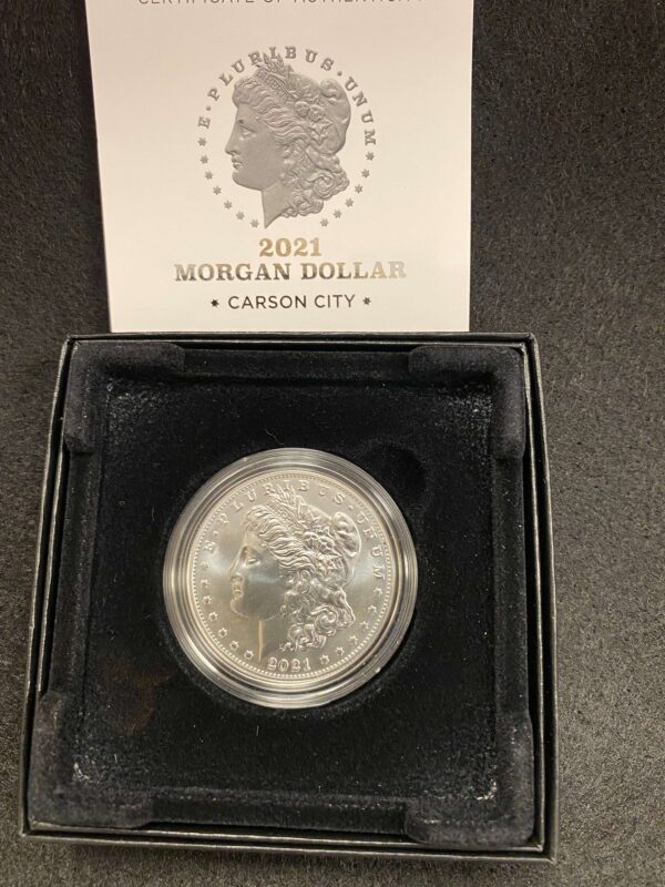 A silver dollar sitting in its box.