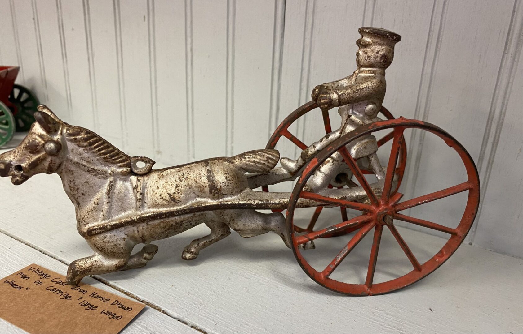 A metal horse and carriage with a man riding it.