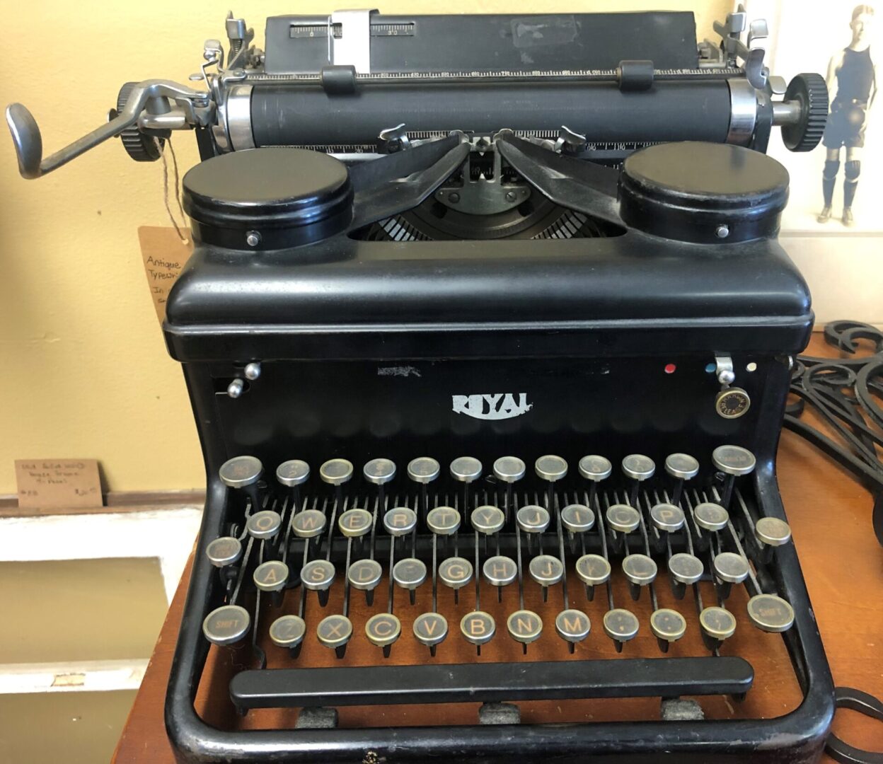 A black typewriter sitting on top of a wooden table.