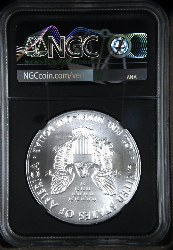 A silver coin is displayed in front of an angc sign.