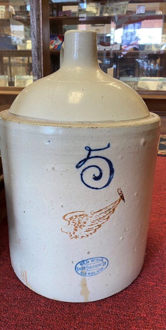 A white jar with numbers and angels on it.
