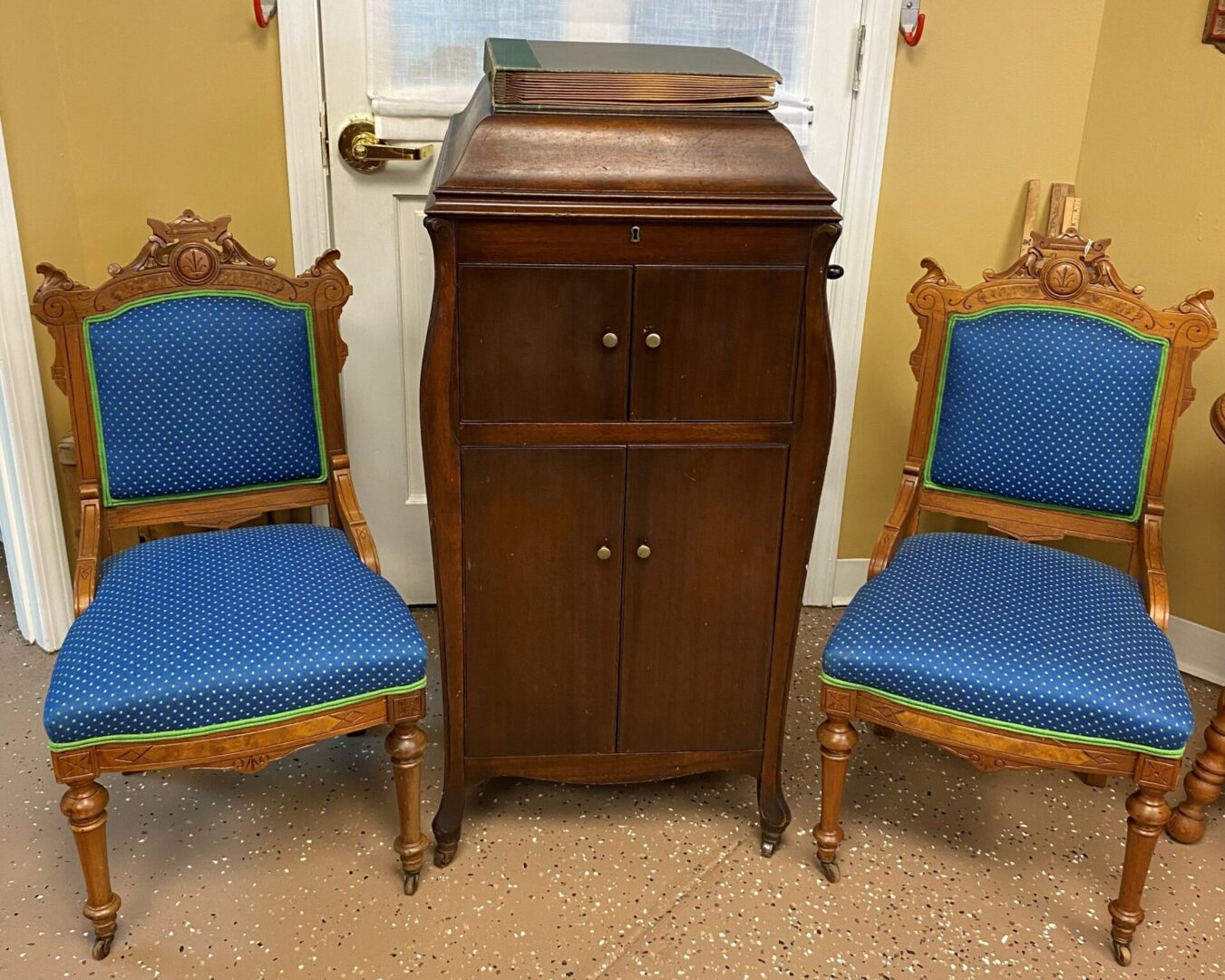 Two blue chairs and a cabinet in front of the door.