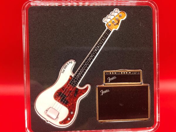 A fender bass guitar in a display case featuring the DYNAMIC DUO - 2X Fine Silver Shaped Coin Set.