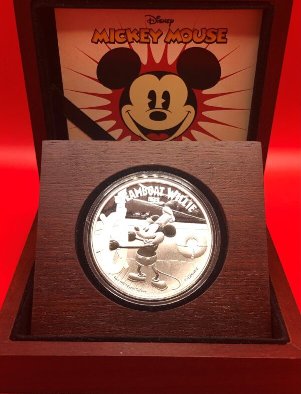 A silver mickey mouse coin in a wooden box.